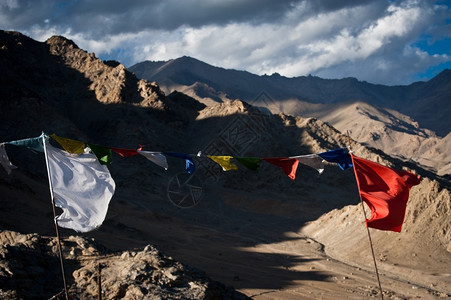 九华山地藏传统的高地信仰印度拉达赫莱海拔30米喜马拉雅山地和蓝日落天空上风吹着佛教祈祷的旗帜背景