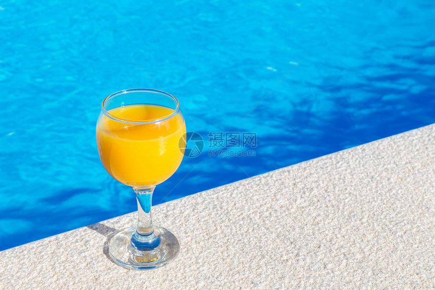 泳池旁的一杯橙汁图片