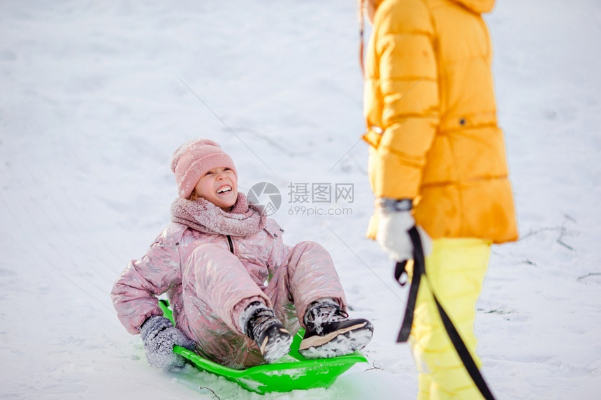 喜悦享受可爱的小女孩在雪中滑和户外玩地游在圣诞节前夕家庭度假在寒冬雪日可喜的快乐小女孩滑雪天图片