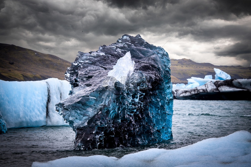 春天JokulsarlonGlacierLagoon附近冰岛钻石海滩黑沙上被冲到冰块洗过云图片