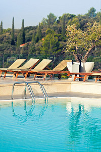 入口克罗地亚细节阳光明媚的一天带游泳池梯子的阳床和雨伞图片