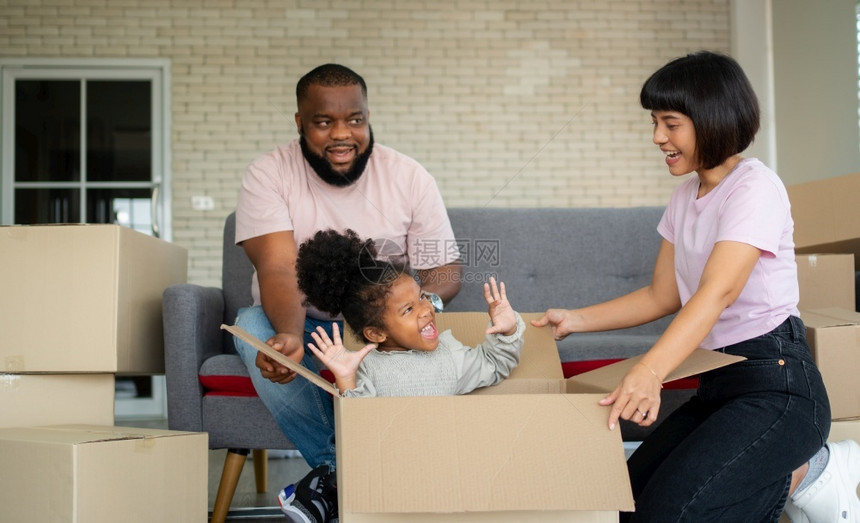 混合种族家庭在购买房地产后第一天搬到新房子后就坐在沙发上休息新的家庭开始生活的概念是新家庭开始生活的概念一种抵押非洲人图片
