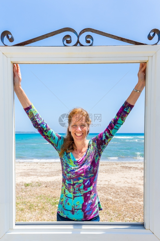 透视在希腊凯法洛尼亚海岸的蓝和滩附近的窗户上欢乐欧洲妇女白种人脸图片