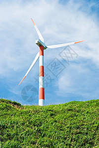 产生乡村的电云蓝色天空下绿山丘的清洁能源概念风力涡轮机背景图片