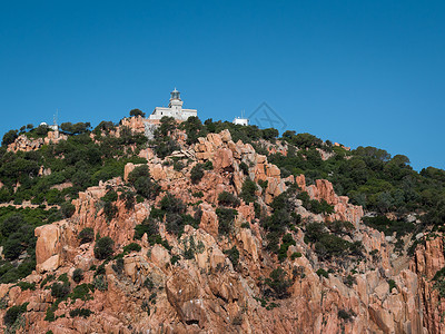 地中海航的意大利边岩石和断崖上的撒丁岛海岸线白灯塔建筑的图片