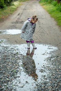 雨天穿着雨衣的小女孩村庄高清图片素材