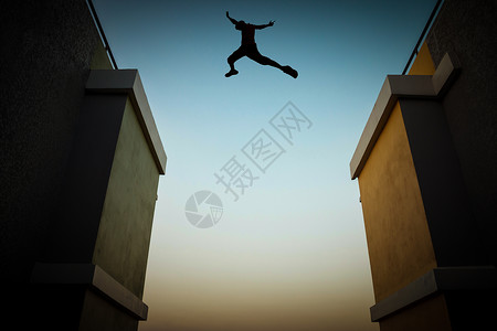 胆大安全高度一个人跳过两栋高楼之间的悬崖背影上写着一个男人的轮廓飞跃背景