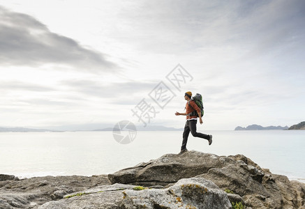 背着包的人跑过岩石天空登山者生活图片