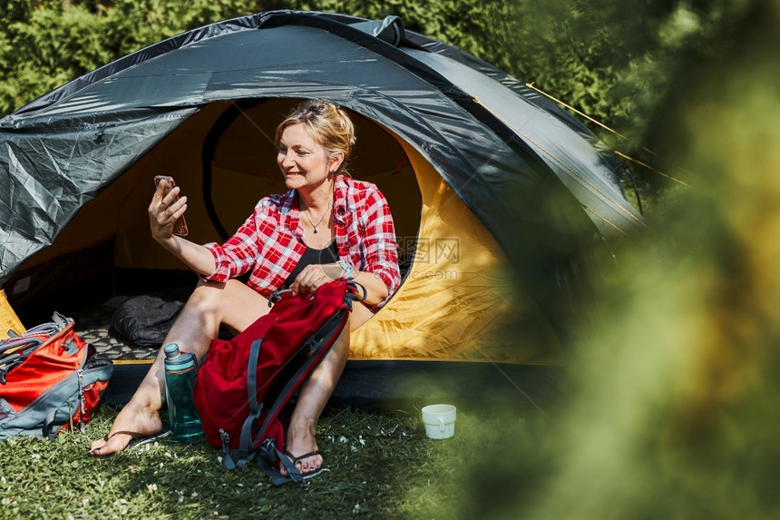 女在暑假期间坐露营妇女帐篷的里放松在中休息与自然质相近的户外度假营地生活概念跃地在野外渡假游客视频运动图片