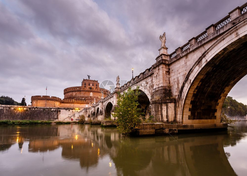 位于意大利黎明的罗马蒂贝尔河上圣天使城堡和桥灯地标历史图片