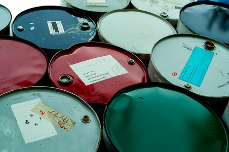 生锈的制造业蓝色绿和红油桶钢铁储箱有毒废物仓库危险化学桶加上警告标签包装桶中工业废物厂危险储存中的工业废物危险化学品桶背景图片