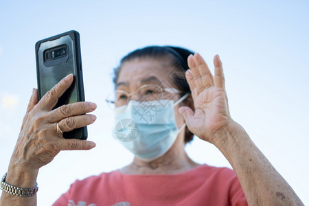 科技及你让在公园使用她的智能手机与家人科技及老年聊天的概念校对Portnoyunorghwki移动的一种年长背景