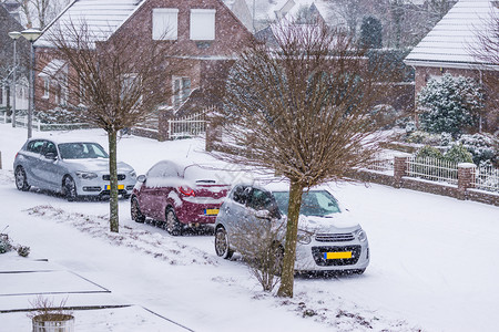 街道疾降季节荷兰的村街上停泊汽车被雪覆盖寒冬日冷荷兰天气下雪的降背景