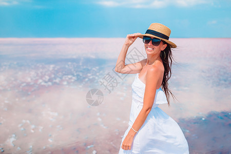 粉色的女人在红盐湖的肖像在阳光明媚的夏日戴帽子在粉红盐湖散步户外景观图片