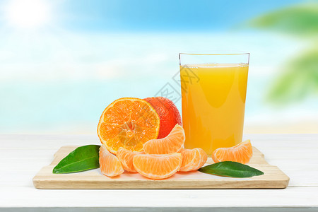 沙滩前的橘子和果汁图片
