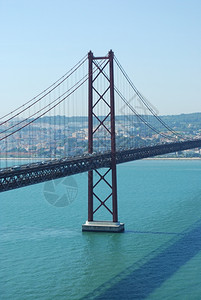 沟通在葡萄牙里斯本著名的阿布里尔25号桥和旧萨拉扎大城市的船图片