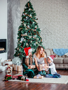 圣诞树下母亲和孩子交换礼物图片