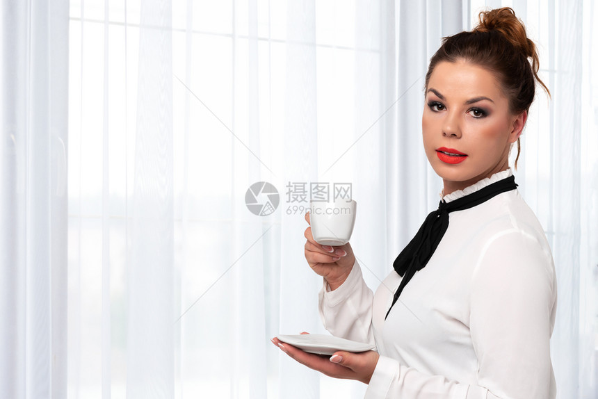 美丽优雅的女士握着一杯咖啡在奢华室内复制空间背景上享受咖啡的口味和风笑声女商人杯子图片