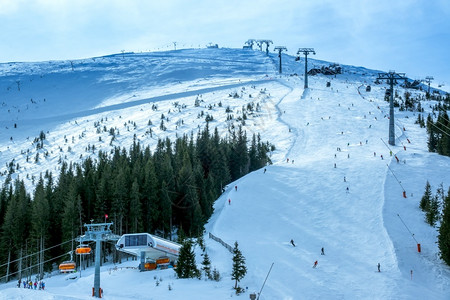 仅旅游亚斯纳两行滑雪升起太阳几乎无法穿透云层滑雪斜坡和天空升起图片