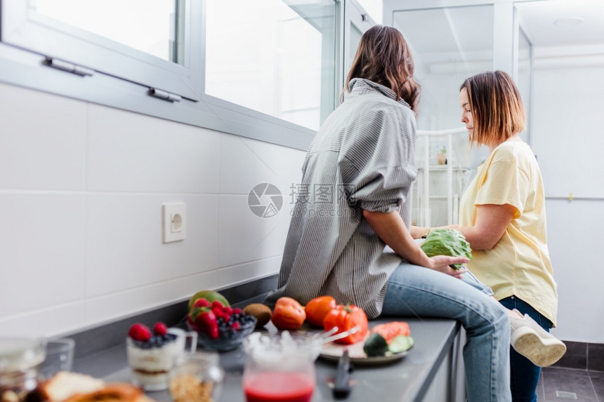 妇女在厨房里准备健康食品与蔬菜一起在厨房里玩蔬菜享受娱乐概念饮食营养团队微笑喜悦图片