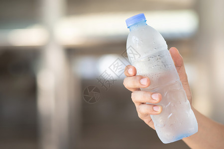 瓶子一种个人喝冷水因为天气非常炎热所以他喜欢喝冷水抓住背景图片