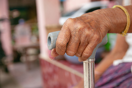 一种女士手握拐杖的老女人手看护图片
