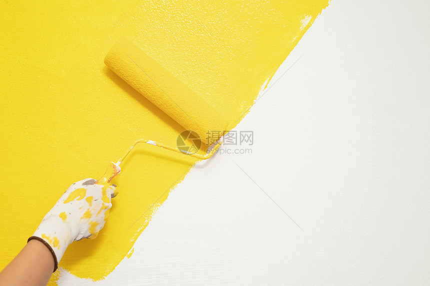 油漆刷关闭地墙壁上手工画家人的绘用黄色彩涂漆公寓进行翻新留下空复制间在外边写描述文字工具修理内部的图片