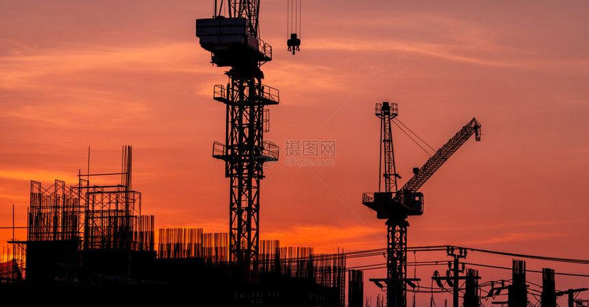 Crane在建筑工地使用雷el提升设备建筑用钢铁和混凝土制成的Crane对橙色日落天空的工程进行冲刺作Crane针对橙色日落天空图片