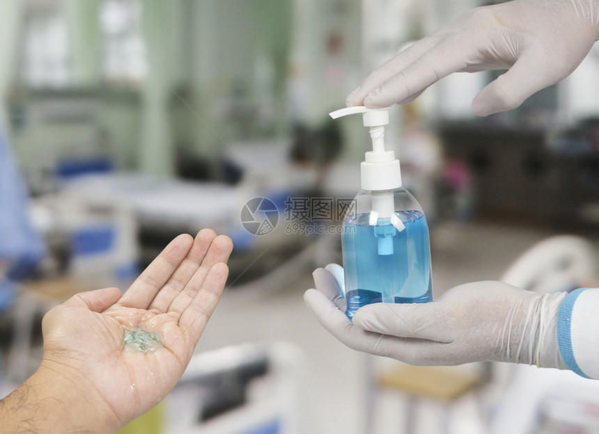 蓝色的健康医生手中酒精消毒剂瓶用于防止带有复制空间的感染预防CoronaCovid19泵图片