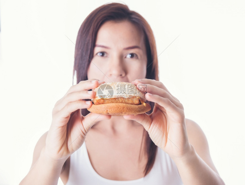 零售白种背景吃汉堡的亚洲美容女快速食物脂肪健康垃圾食品概念c健康垃圾食品芝士汉堡触碰图片