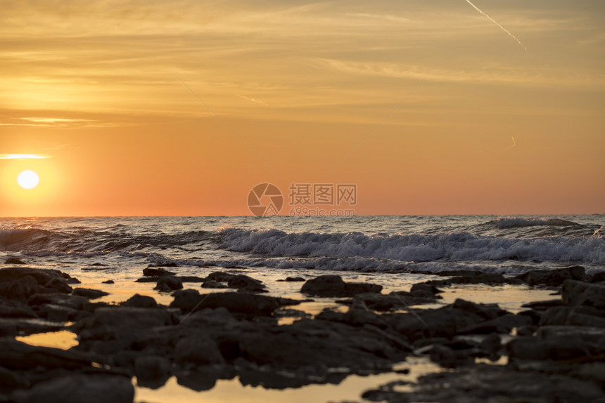 海滩清晨长期照射海景水面有太阳和石块风景优美接触图片
