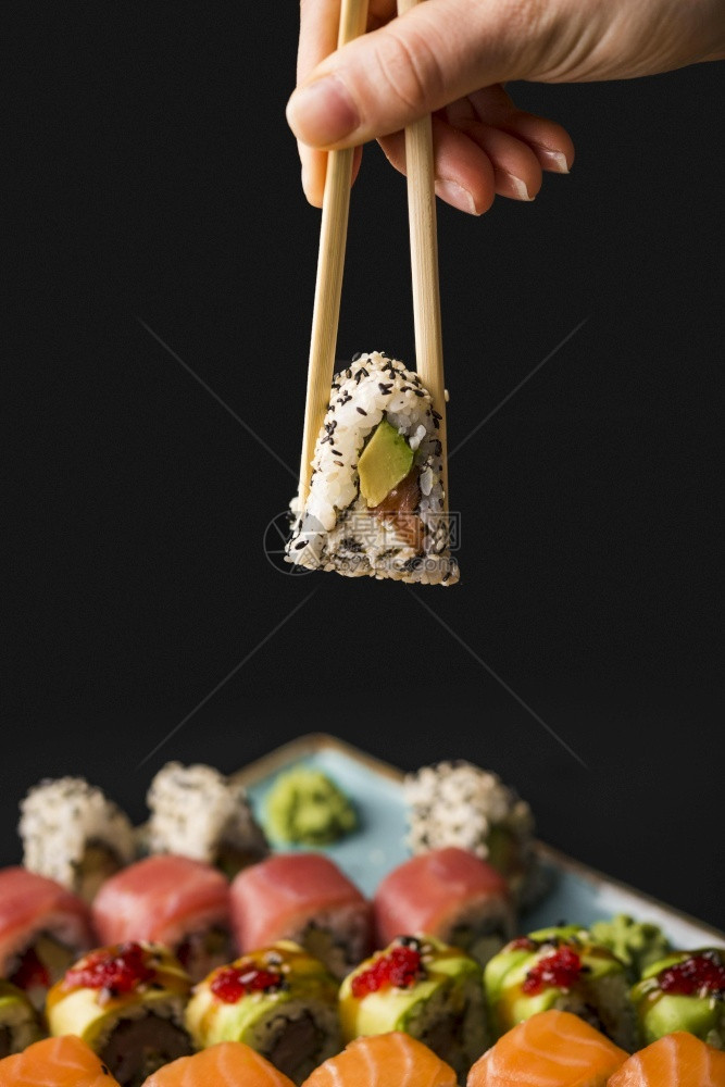高清晰度照片显示用筷子抓着寿司的照片显示优质有高品质照片显示手人们细卷图片