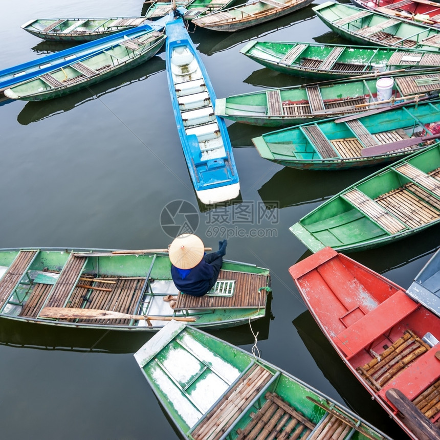 NinhBinh越南TamCoc河上一条传统船只坐着同冠的越南妇女旅行地貌和目的漂浮血管吸引力图片