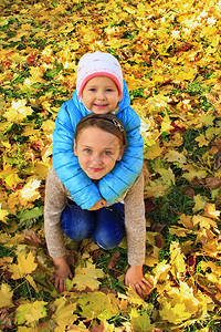 秋天落叶里玩耍的姐姐和妹妹图片