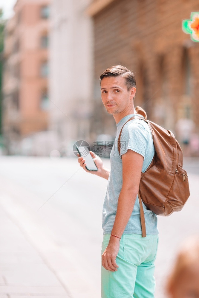 高加索旅游者手持智能机在罗马废弃的意大利街上行走年轻城市男孩度假探索欧洲城市BoyCaucasian与智能手机在欧洲街上行走笑声图片