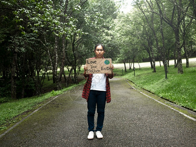 一名持有自然保护标志的女愿者在森林中属于自然界世环境日的概念是世界环境日的理念之一种地球回收图片
