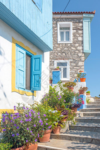 旅行希腊萨莫斯Kokkari市中心有梯子和花盆的小巷外部房屋图片