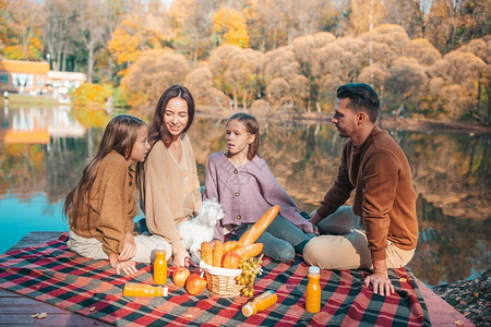 农村秋天在湖边欢乐家庭野餐的年轻在秋天公园野餐篮子一种图片