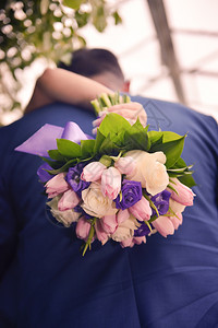 波西米亚家庭白种人新郎手上漂亮的婚礼花束在新娘手上接吻图片