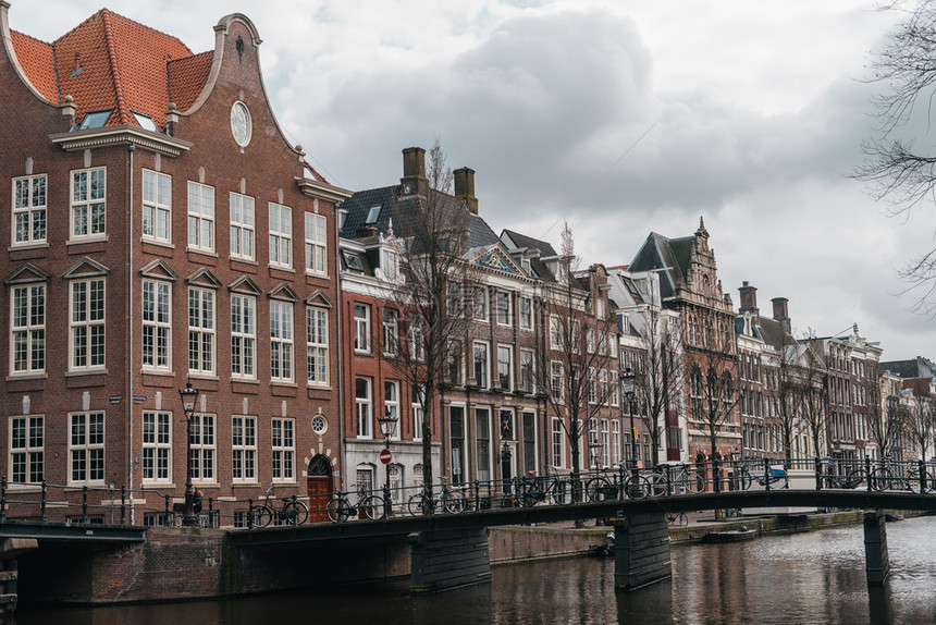 传统的具有阿姆斯特丹河流运漂亮房子的可舒适欧洲建筑目地街道图片