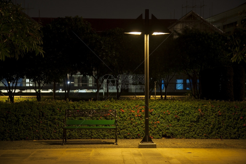 黑色的户外夜间在公园内的一个里用灯下面的座椅等待图片