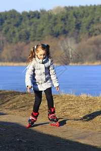 地面放松年轻漂亮的女孩在地上穿旱冰鞋年轻女孩在地上穿旱冰鞋孩子图片