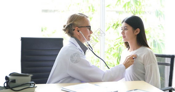 医生使用听诊器给病人听诊治疗图片