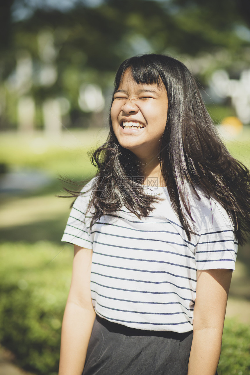 乐趣模型年轻亚裔青少的笑脸展示了风吹动的前额发毛漂亮的图片