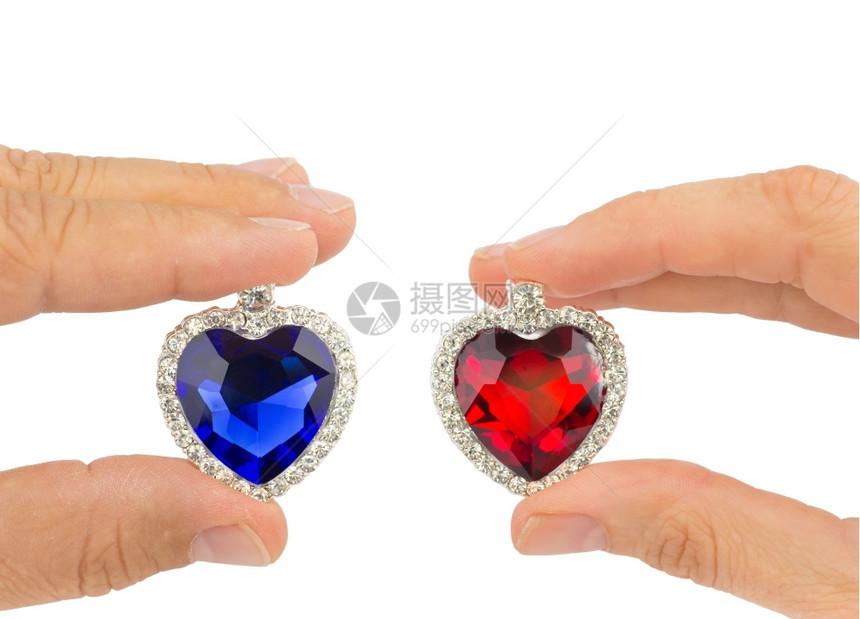 宝石男人和女的手指握蓝红首饰心在白色背景上被孤立荷兰火花图片