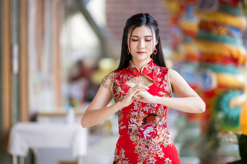 女士身着新年节在泰中神庙举办新年庆典红传统香藏装饰的亚裔年轻女子她的长相笑脸如肖像般美丽节日真正的图片