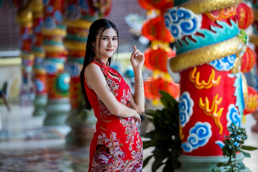 吸引人的新身着年节在泰中神庙举办新年庆典红传统香藏装饰的亚裔年轻女子她的长相笑脸如肖像般美丽人们图片