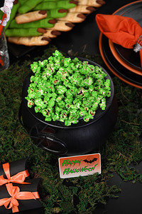 Cauldron绿色甜爆米花供食人和万圣节吃款待晚上可口图片