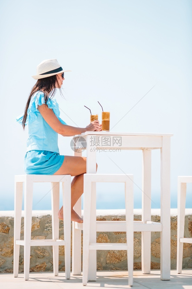 在海边喝咖啡的女士图片