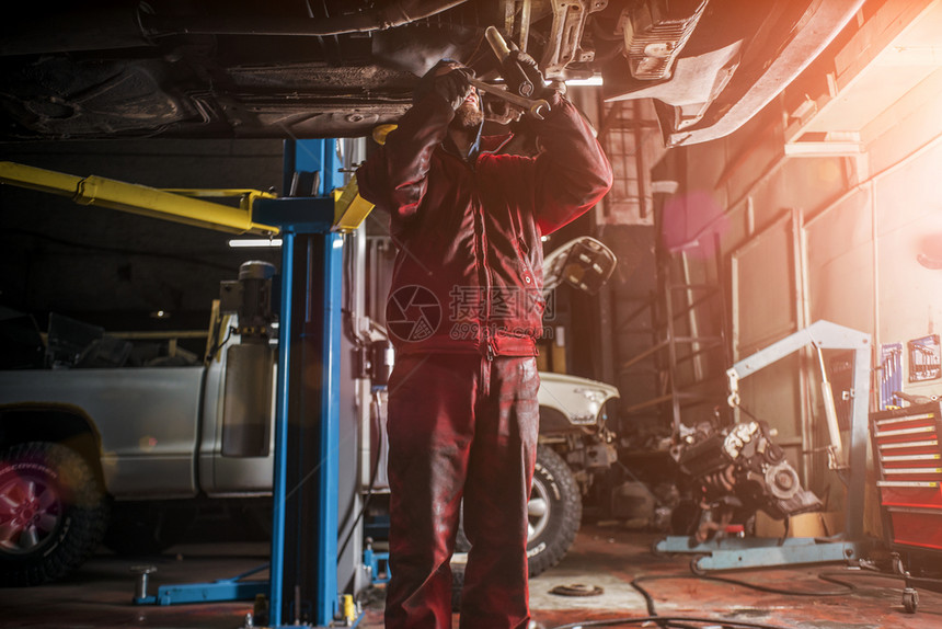穿红色工作服的年轻天主教青男子用专业工具修理汽车健康行业引擎图片